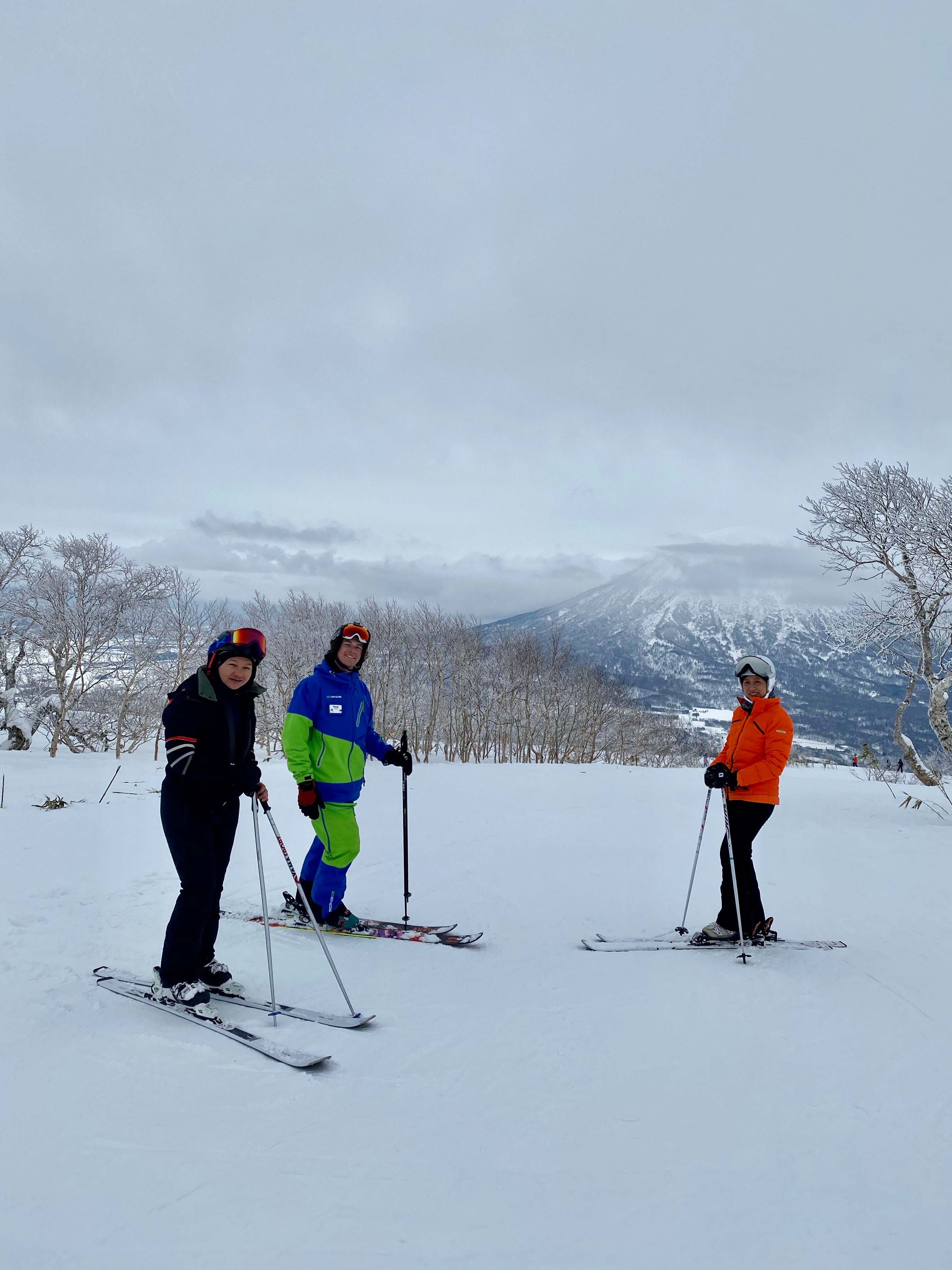 Noah guiding two clients on a Niseko slope, Mt Yotei in the background